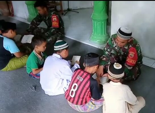 2 Personil Satgas TMMD kodim 0207 Simalungun mengajarkan Mengaji Alqur’an kepada anak anak di Lokasi TMMD 107